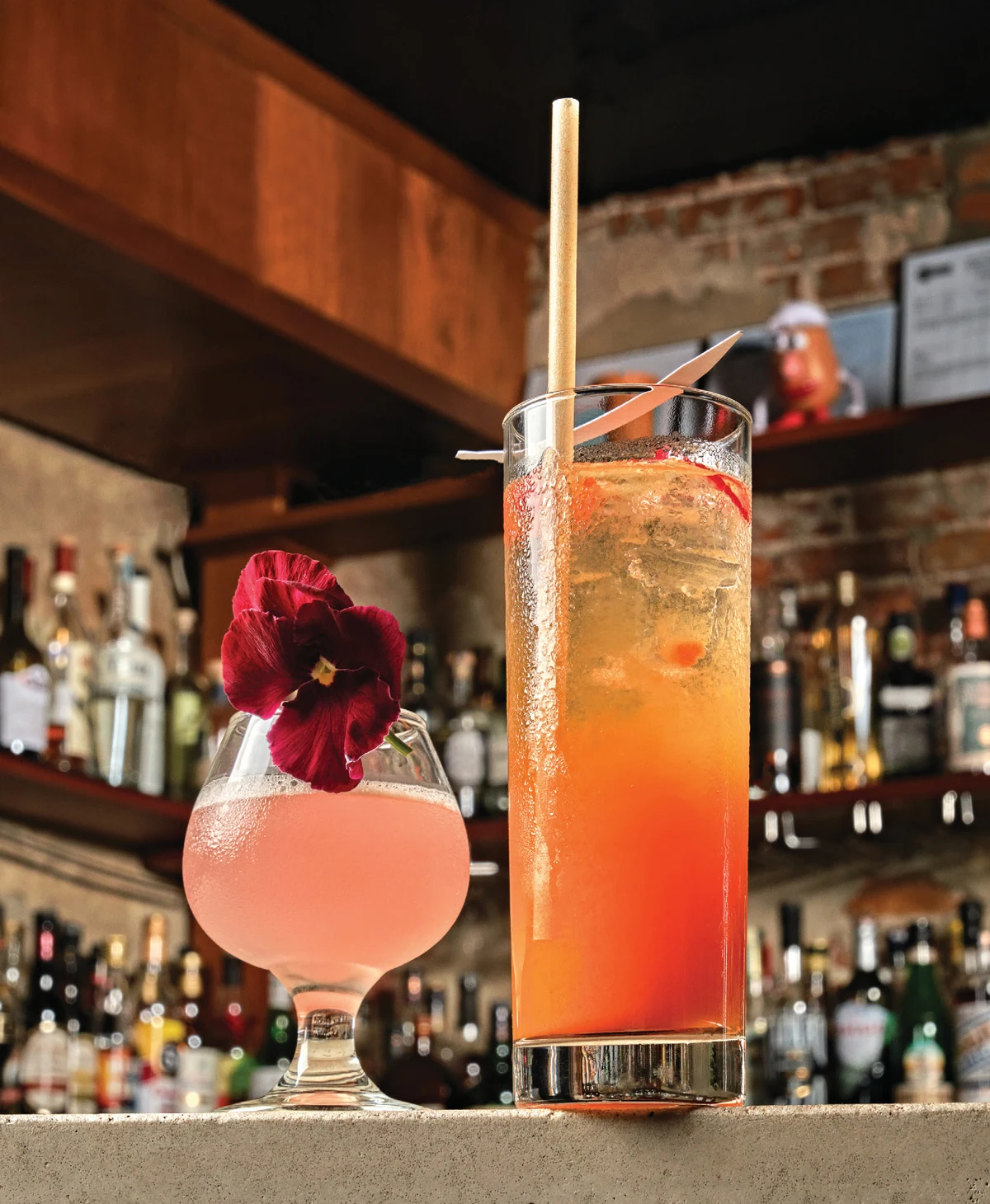 Two non-alcoholic cocktails on a bar, garnished with a nasturtium, photographed for the Liquid Assets feature